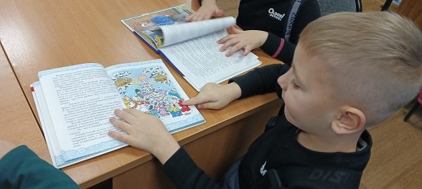Библиотека Печенга МБКПУ Печенгское МБО День рождения Деда Мороза Дети показывают иллюстрации с Дедом Морозом